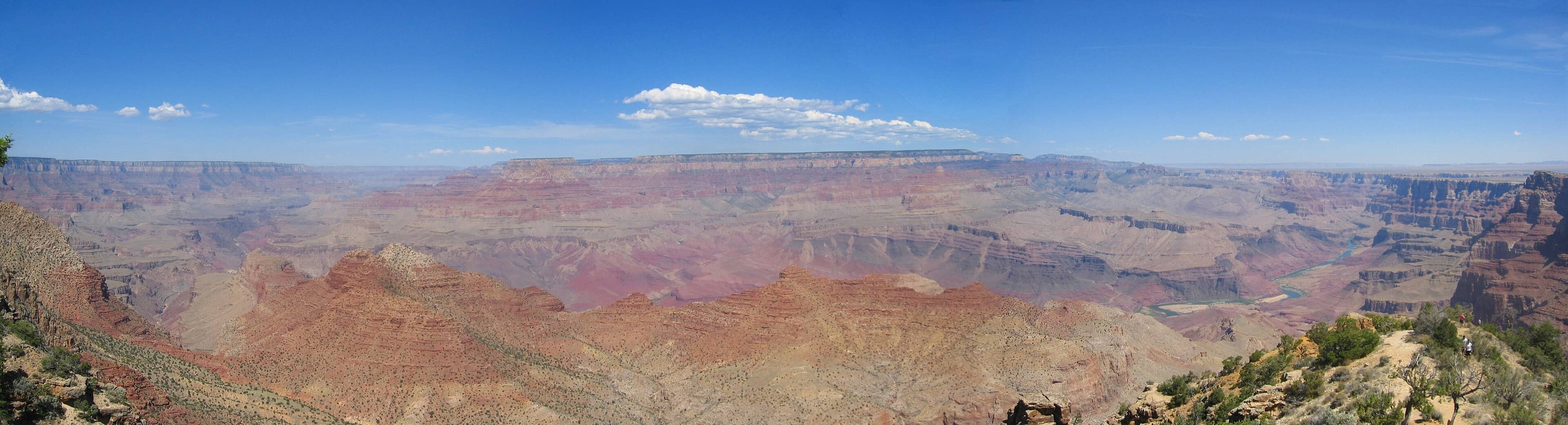 Sweeping daytime panorama of the Grand Canyon's South Rim under a clear blue Arizona sky. 
