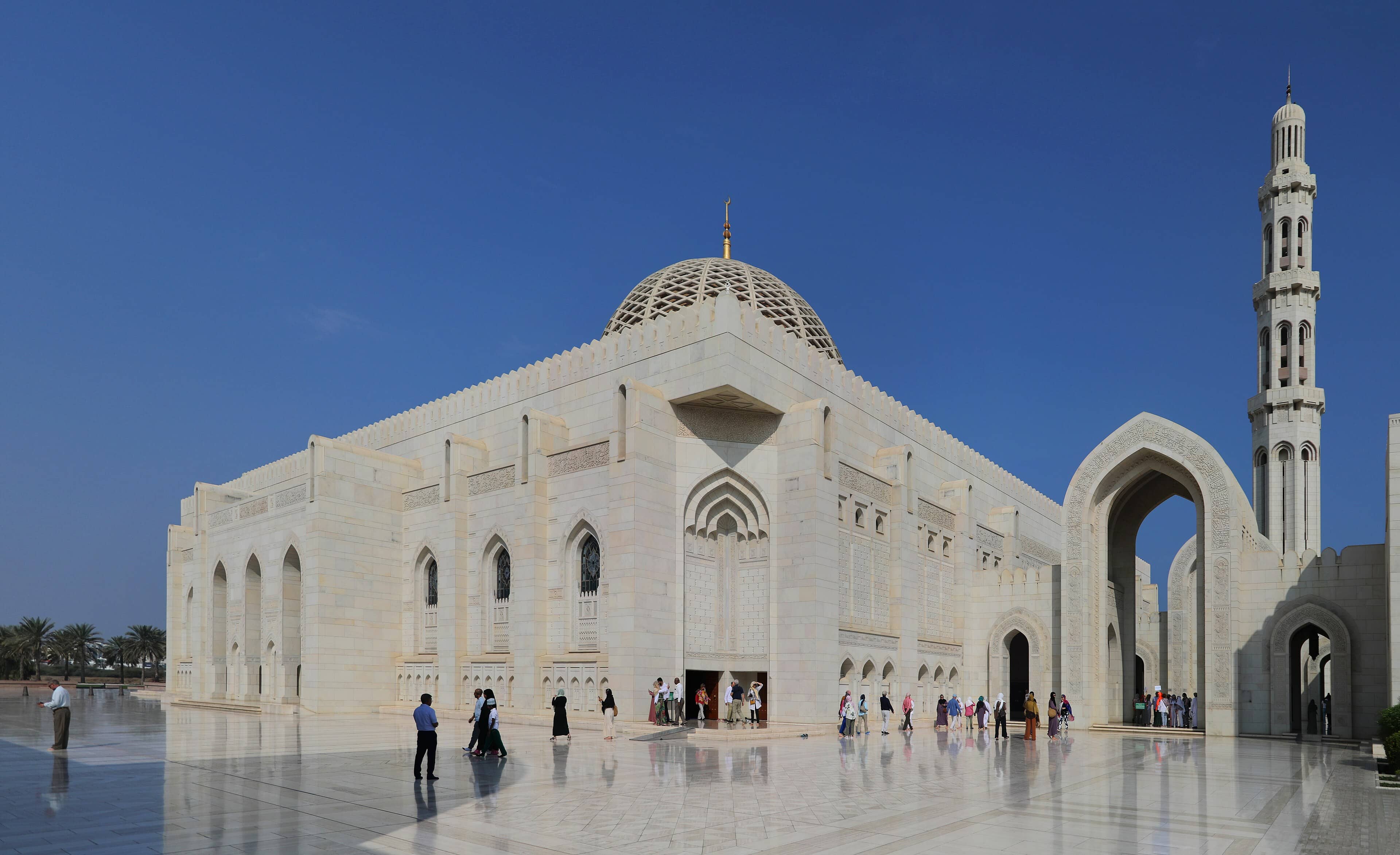 The white marble Sultan Qaboos Grand Mosque in Muscat gleaming under bright blue skies.</br>Sorry — correcting: sunlit exterior of the Sultan Qaboos Grand Mosque in Muscat, Oman.<Br>