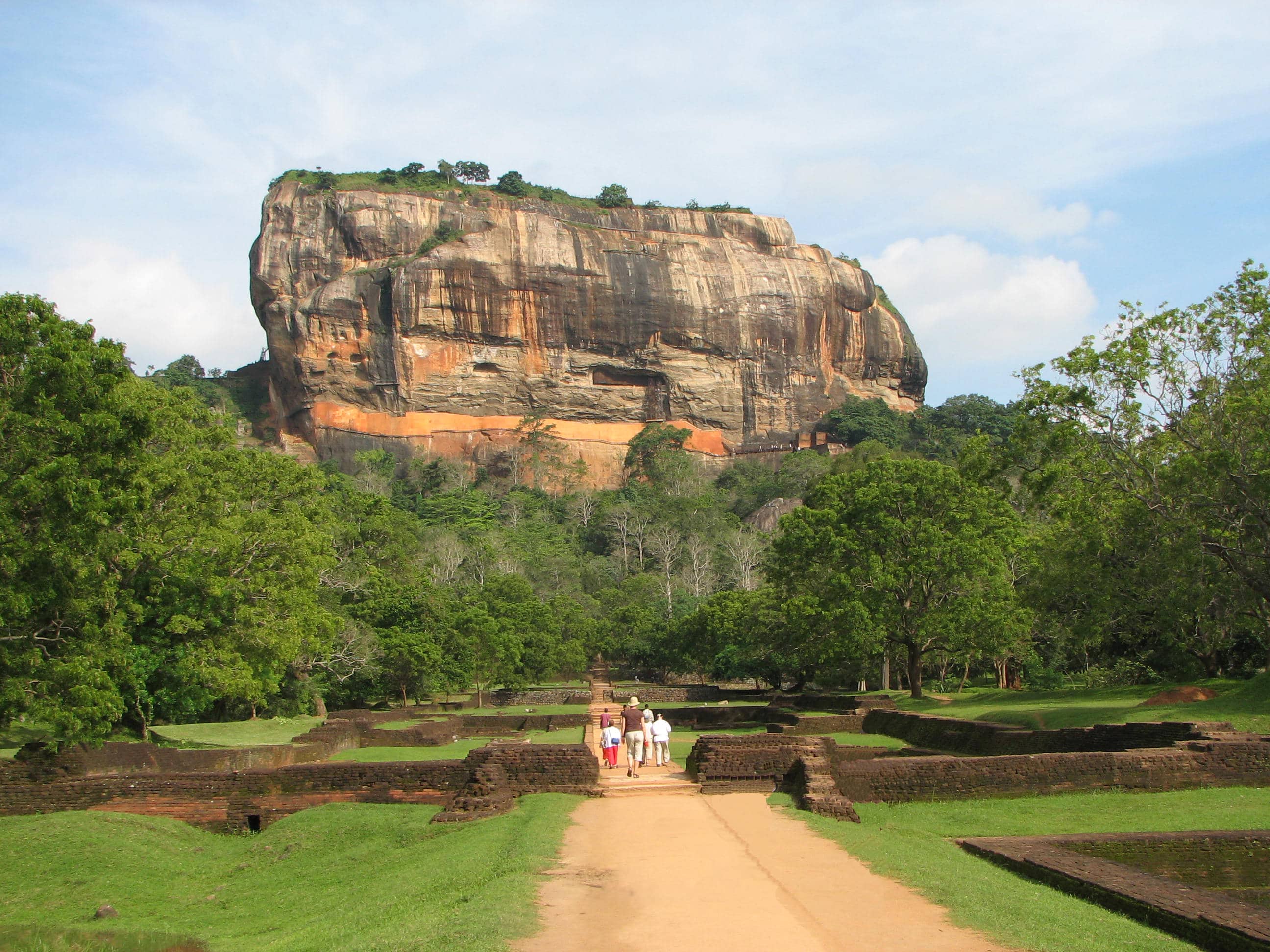Sigiriya Rock Fortress rising above green water gardens in bright sunshine, Sri Lanka
